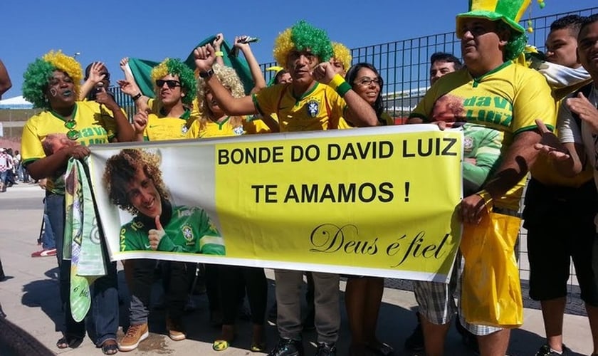 Com "Deus é fiel" escrito em faixa, grupo homenageia David Luiz