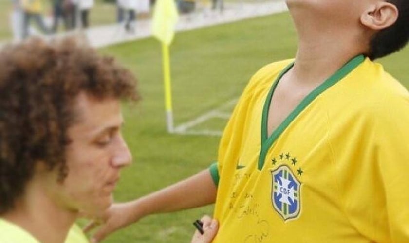 Garoto invade treino da Seleção e David Luiz retribui carinho: "Agradeço a Deus"