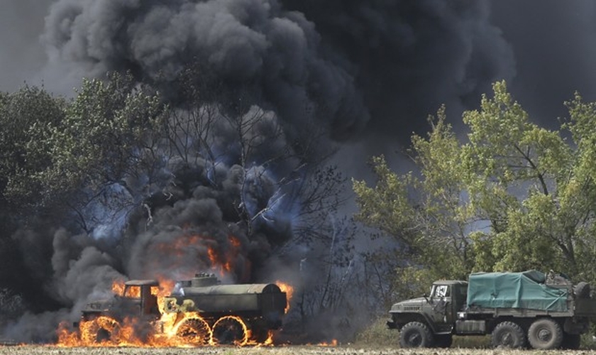 Veículos militares queimam em rodovia de Berezove, leste da Ucrânia, nesta quinta-feira (4) 