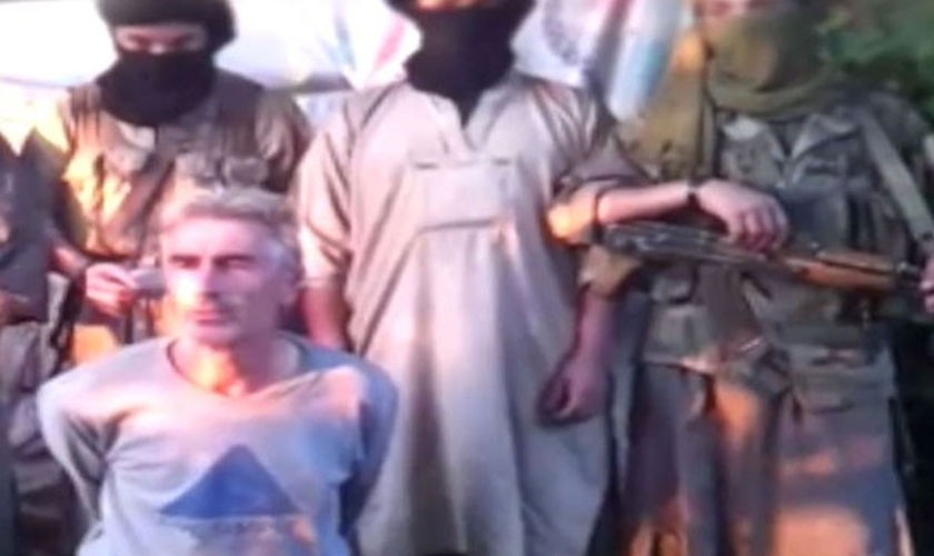 Vídeo mostra refém dominado por militantes armados e encapuzados