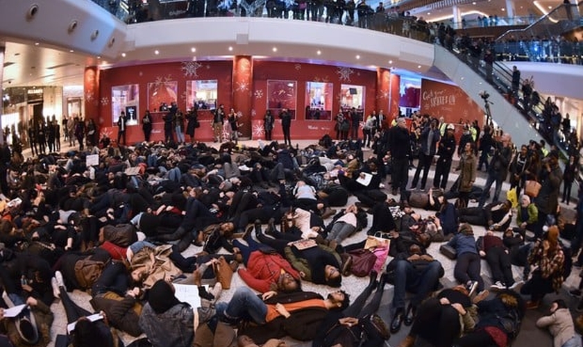 Grupo de manifestantes se deita em shopping de Londres para apoiar os protestos contra morte de negros por policiais brancos dos EUA (Foto: LEON NEAL/AFP)