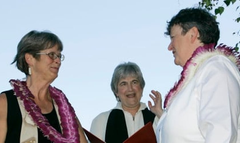 Pastora da PCUSA, Jane Spahr (ao centro) celebra um casamento homossexual, entre Sherrie Holmes (esquerda) e Sara Taylor (direita).