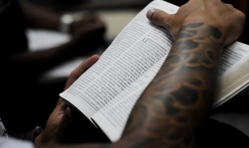 Jovem segurando a Bíblia durante culto em uma igreja evangélica.