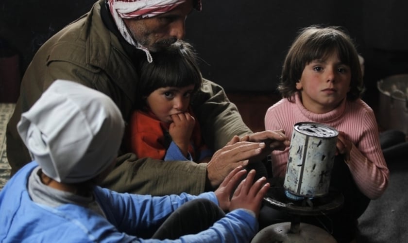 Refugiado alimenta sua família em campo, na Jordânia. (Foto: Reuters/Muhammad Hamed)