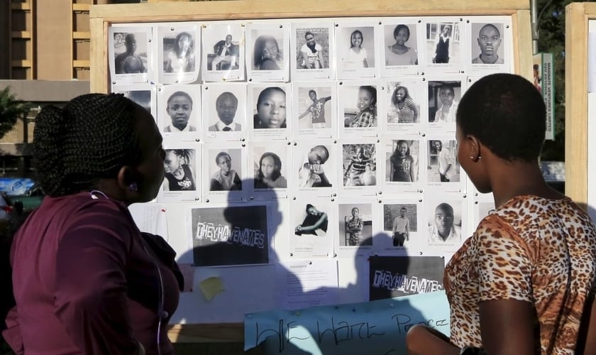 Pessoas olham um mural com fotos de alguns dos 150 estudantes assassinados na Universidade de Garissa, durante a trágica manhã de 02 de abril de 2015 (Foto: Reuters)