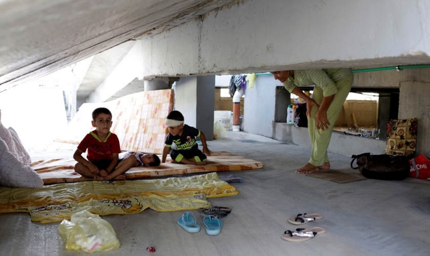 Crianças cristãs que fugiram da violência do Estado Islâmico em Qaraqosh, descansam sobre colchões velhos, em prédio abandonado, na região de Arbil - norte de Bagdá. (Foto: Reuters)