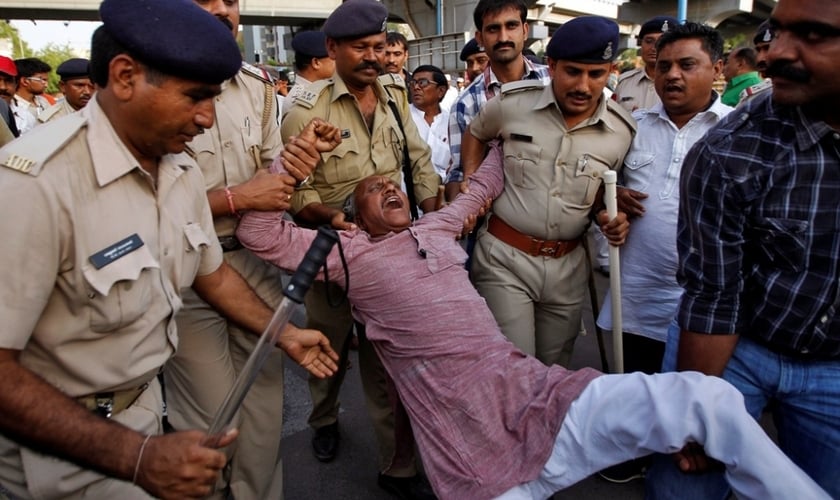 Membro da casta dos dalits continua protestando, enquanto é detido pela polícia indiana, na cidade de Ahmedabad, em abril de 2014 (Foto: Reuters)