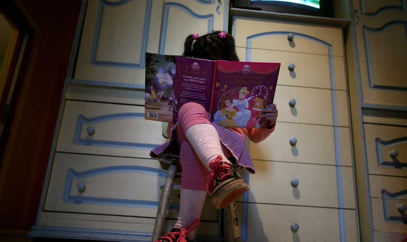 Lulu, uma 'menina' transgênero, lê um livro em seu quarto em sua casa em Buenos Aires. (Foto: Reuters)