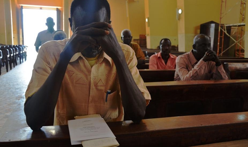 Cristão sudanês ora dentro do templo de igreja. (Foto: La Stampa)