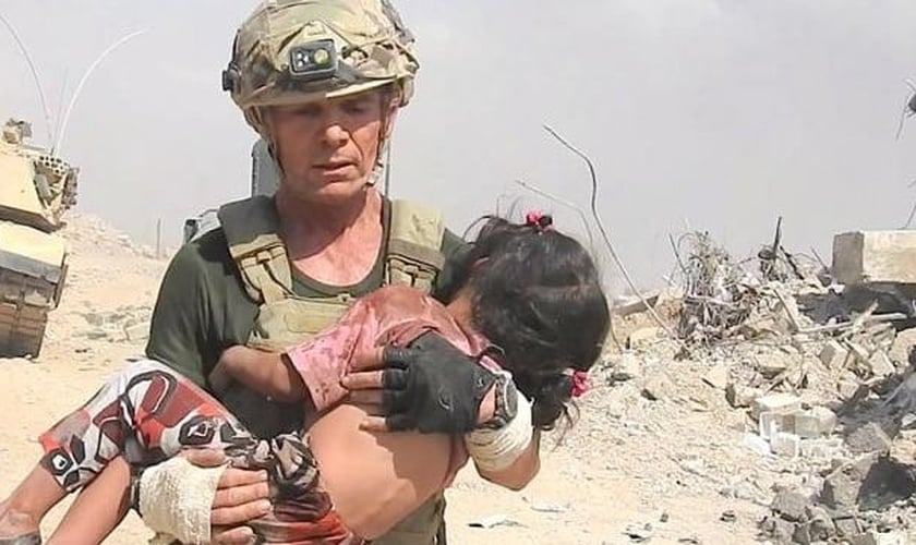 David Eubank carrega criança, vítima do Estado Islâmico, nos braços. (Foto: Free Burma Rangers)