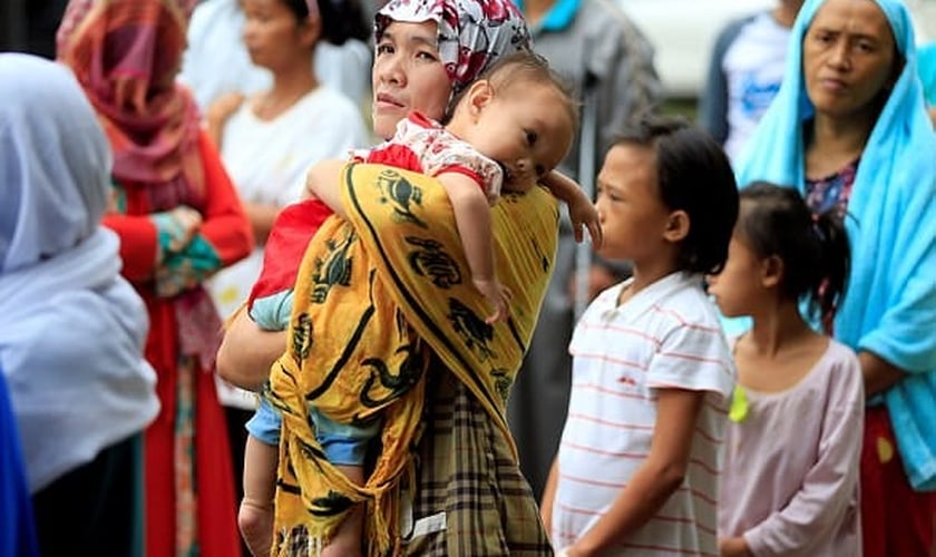 Mãe segura seu filho em meio ao caos instalado nas Filipinas, após cerco de terroristas. (Foto: Reuters)