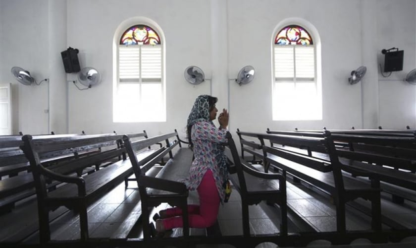 Imagem ilustrativa. Mulher orando em uma igreja na Malásia. (Foto: Reuters)