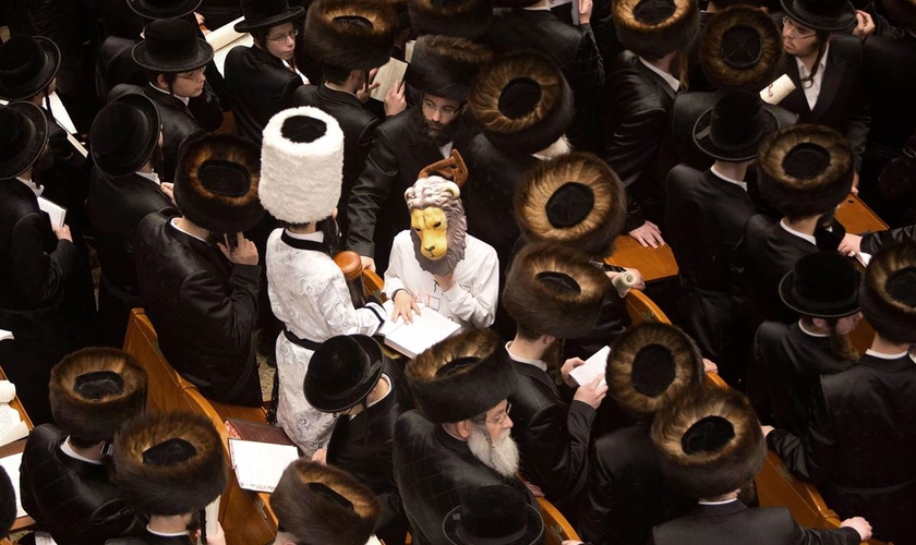 Judeus lendo o livro de Ester e filhos fantasiados durante o Purim, em Jerusalém. (Foto: AFP/Getty Images)