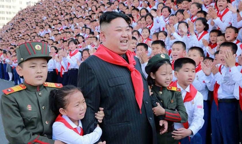 Crianças posam para foto com ditador Kim Jong Un. (Foto: Daily Express)