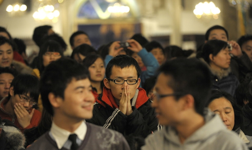 Cristão ora durante culto na China. (Foto: Foreign Policy)