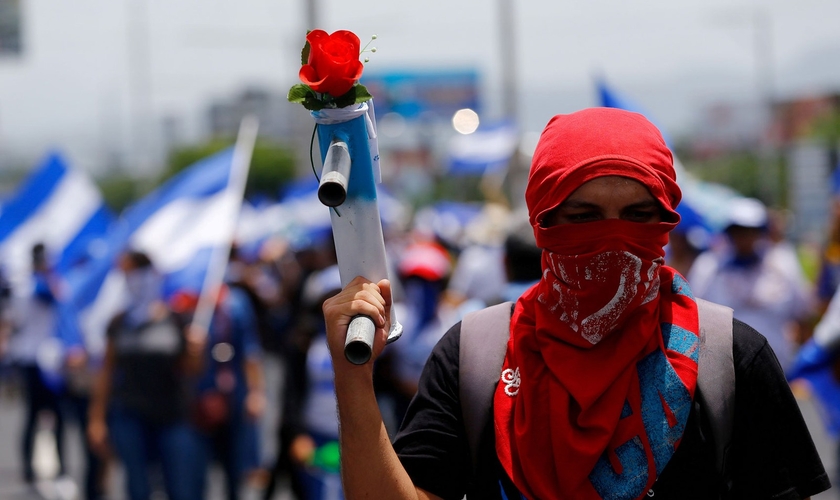 Manifestante exibe morteiro caseiro com uma flor durante marcha em Manágua, na Nicarágua. (Foto: Reuters/Oswaldo Rivas)