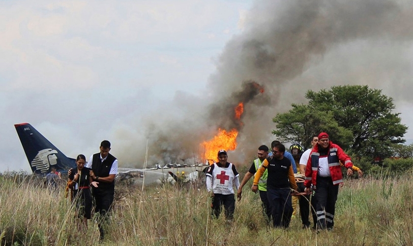 Socorristas carregam ferido em maca durante resgate após acidente com avião da Aeroméxico. (Foto: Red Cross Durango/AP)