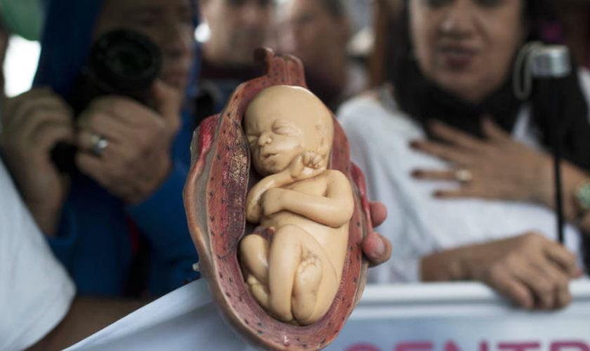 Feto feito de plástico em evento católico contra a legalização do aborto, no Rio de Janeiro. (Foto: Silvia Izquierdo/Associated Press)