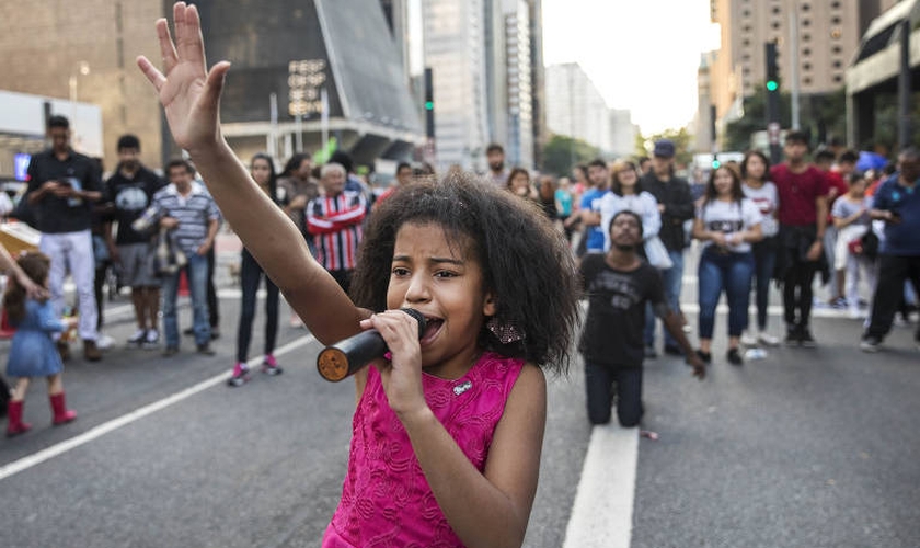Aos 10 anos, Vitória de Deus canta e prega na Avenida Paulista. (Foto: Eduardo Knapp/Folhapress)