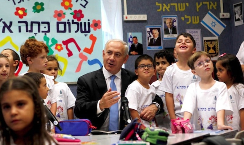 Primeiro-ministro Benjamin Netanyahu junto a crianças em escola. (Foto: Times of Israel)