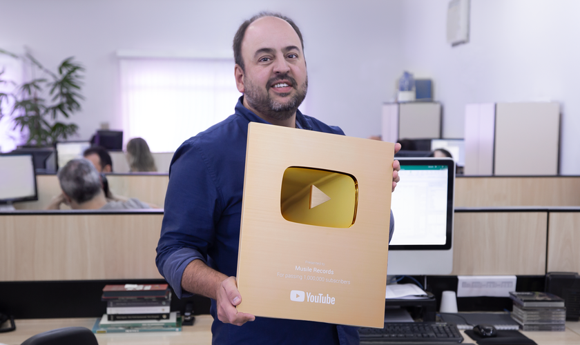Ricardo Carreras, CEO da gravadora Musile Records, segura a placa de 1 milhão de seguidores do canal do YouTube. (Foto: Divulgação).
