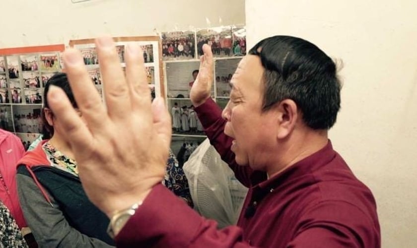 Pastor de igreja doméstica lidera momento de oração, na China. (Foto: ABC News)
