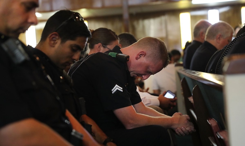 Policiais orando em uma vigília de oração em Dallas, no Texas. (Foto: Spencer Platt/Getty Images)