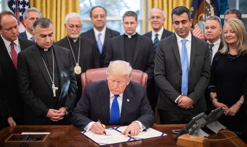 Donald Trump é cercado por líderes religiosos e legisladores no Salão Oval, ao assinar lei de ajuda humanitária. (Foto: Casa Branca/Shealah Craighead)
