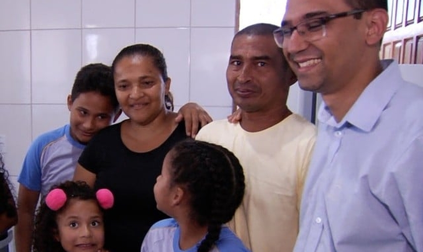 Ao lado dos filhos e do diretor da escola, casal se emocionou com nova casa. (Foto: Reprodução/TV Anhanguera)