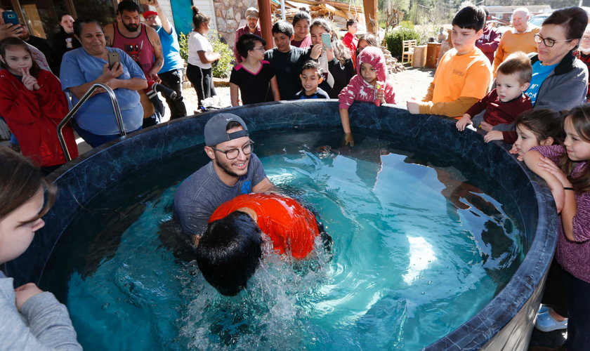 O pastor de jovens, Craig Blaylock, batiza membro da igreja que foi atingida por um tornado. (Foto: AP/Rogelio V. Solis)