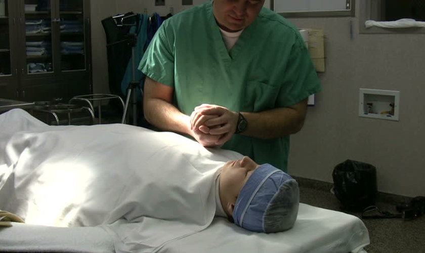 Imagem ilustrativa. Médico em oração com paciente antes de cirurgia. (Foto: John Neff/Shutterstock)