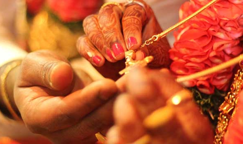 Casal hindu segura pingente nas mãos. (Foto: Marriage.com)