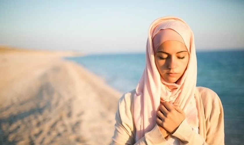 Muçulmana em atitude de reflexão na praia. (Foto: Just Between Us Magazine)