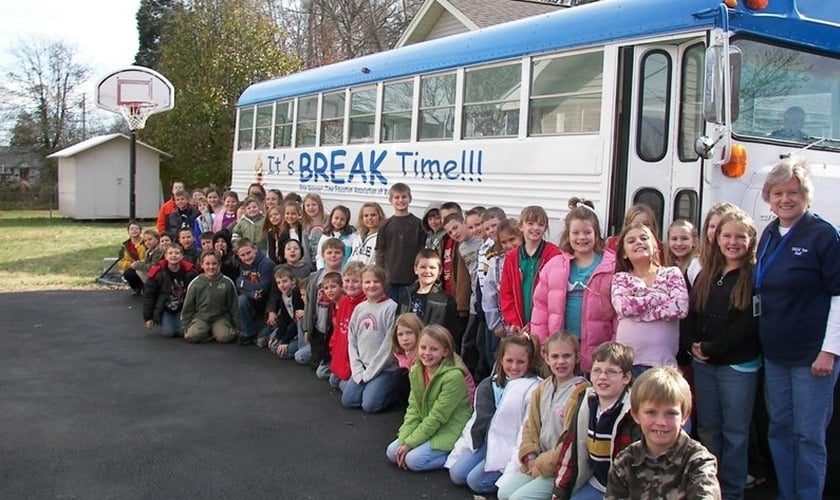 Os estudantes se reúnem em frente ao ônibus, onde aprenderam verdades bíblicas durante o ano letivo passado. (Foto: Reprodução/Bpress)