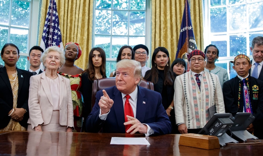 Presidente Trump com o pastor Hkalam Samson, de casaco claro e chapéu, em reunião com sobreviventes da perseguição religiosa em julho. (Foto: Alex Brandon/Associated Press)