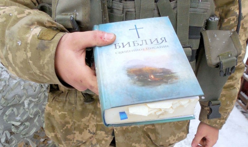 Policial segura uma Bíblia. (Foto: Reprodução/Mission Eurasia)