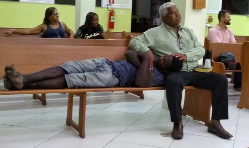 Após receber um copo de água e um abraço, o morador de rua sentiu-se à vontade para reclinar sua cabeça no colo do Sr. Orlando. (Foto: Facebook / Cleberson Santos)