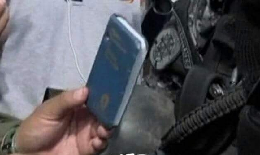Bíblia de bolso que reteve a bala antes que atingisse o peito do policial. (Foto: Reprodução/Facebook)