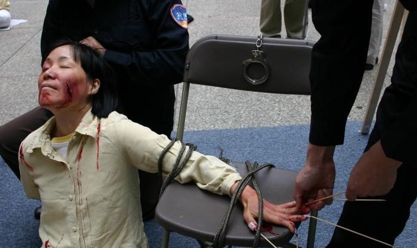 Reconstituição de tortura pela polícia em um centro de detenção. (Foto: Reprodução/Minghui.tv)