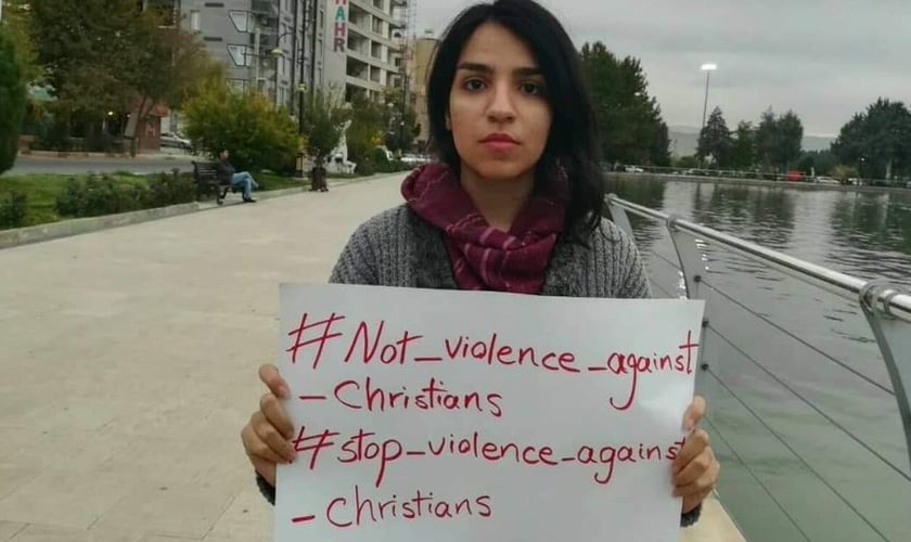 A ativista cristã Mary Fatemeh Mohammadi com placa contra perseguição aos cristãos. (Foto: Reprodução/Twitter)