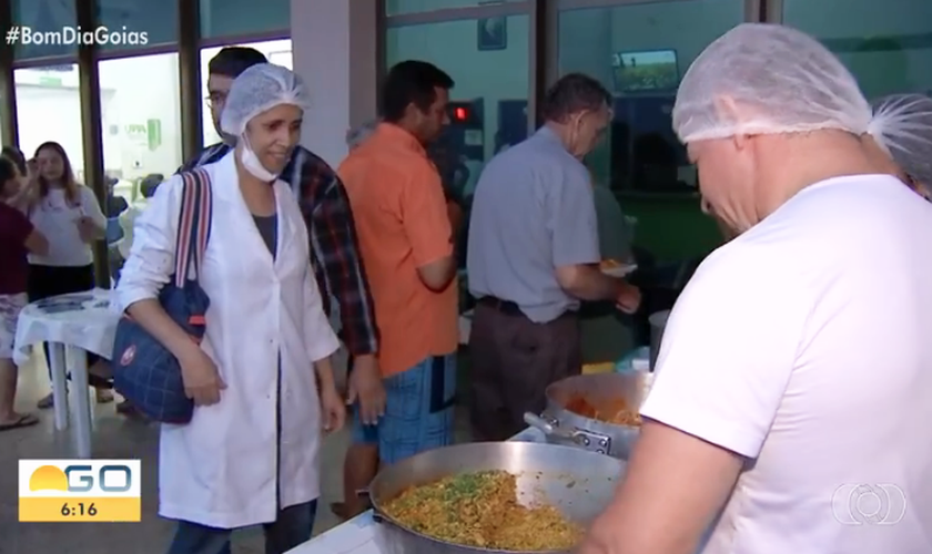 Voluntários da igreja distribuem comida para acompanhantes e funcionários de UPA. (Foto: Bom Dia Goiás/TV Anhanguera)