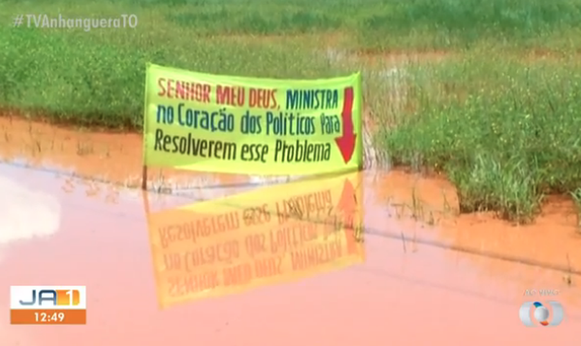 Moradores colocaram faixa com oração para tentar solução para problema. (Foto: Reprodução/TV Anhanguera)