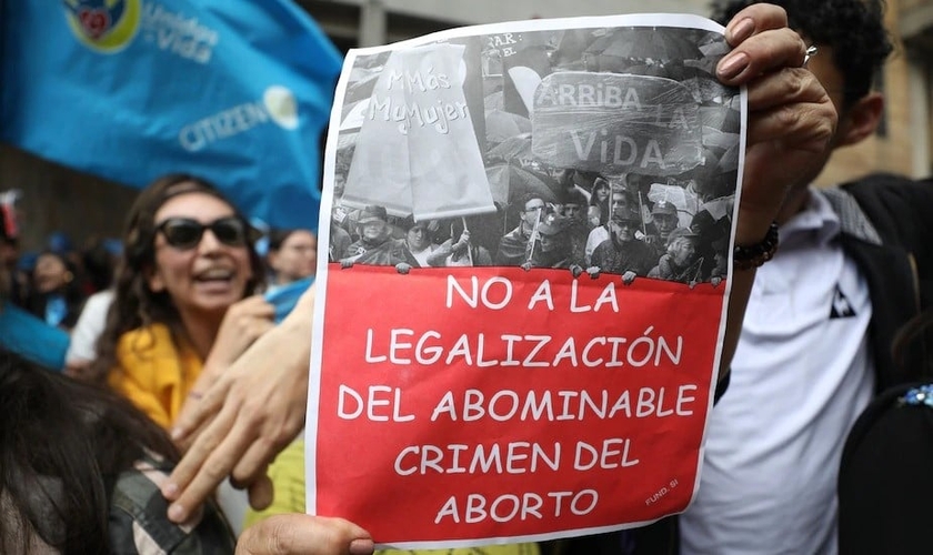 Um ativista antiaborto segura uma placa que diz em espanhol "Não à legalização do crime abominável do aborto", durante um protesto em frente ao tribunal constitucional da Colômbia em Bogotá, em 2 de março. (Foto: Fernando Vergara / AP)