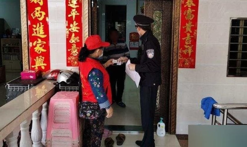 Na cidade de Sanya, na província de Hainan, um membro da equipe da comunidade, juntamente com um policial, vai de porta em porta para verificar as informações de identificação dos residentes. (Foto: Reprodução/Bitter Winter)