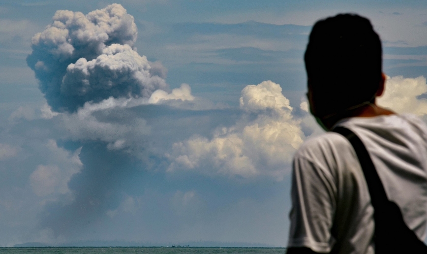 Homem observa fumaça do vulcão Krakatoa em erupção na Indonésia. (Foto: Ronald Siagian/AFP)