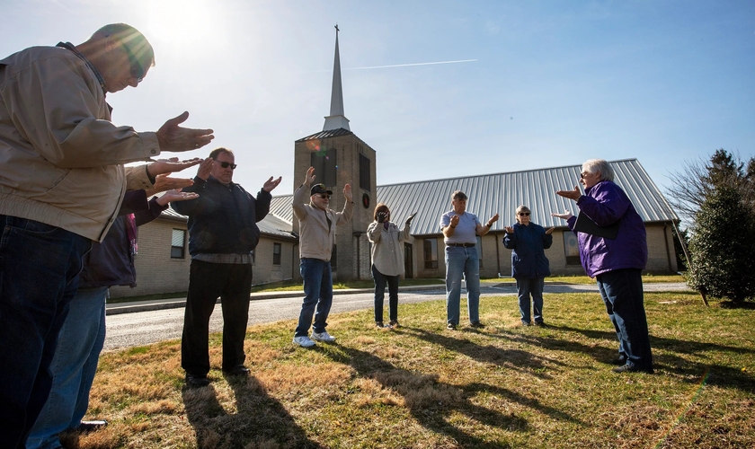 Cristãos oram do lado de fora da igreja. (Foto: Paul Kuehnel/USA Today)
