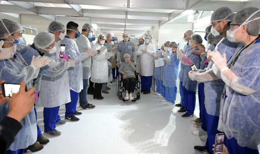 Idosa recebe despedida da equipe de médicos após receber alta em tratamento do coronavírus. (Foto: Fábio Nunes Teixeira /PMG)