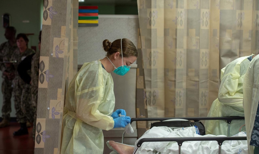Mulher trata paciente em hospital no navio USNS Mercy, implantado para tratar pacientes com Covid-19 na Califórnia. (Foto: US Navy/Erwin Jacob Miciano/Reuters)
