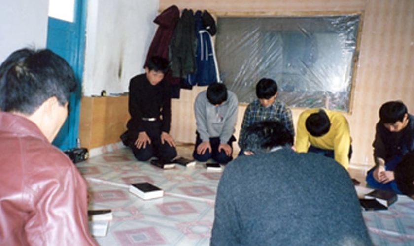 Cristãos oram ajoelhados em igreja clandestina da Coreia do Norte. (Foto: GodReports)