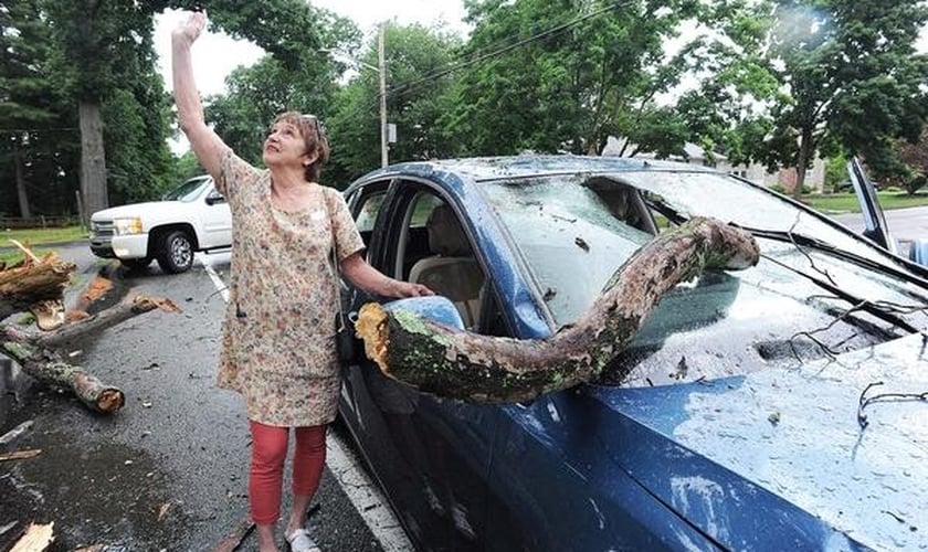 Debby Clish aponta para o céu em agradecimento a Deus, após se livrar de um acidente nos EUA. (Foto: Marc Vasconcellos/The Enterprise)